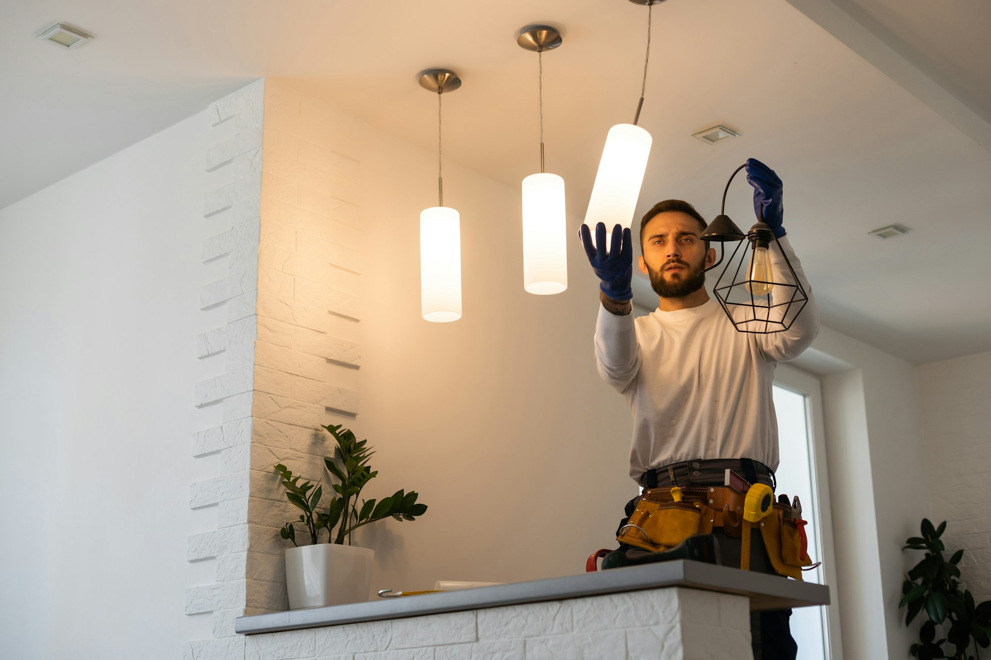 Electrician worker installation electric lamps light inside apartment. Construction decoration